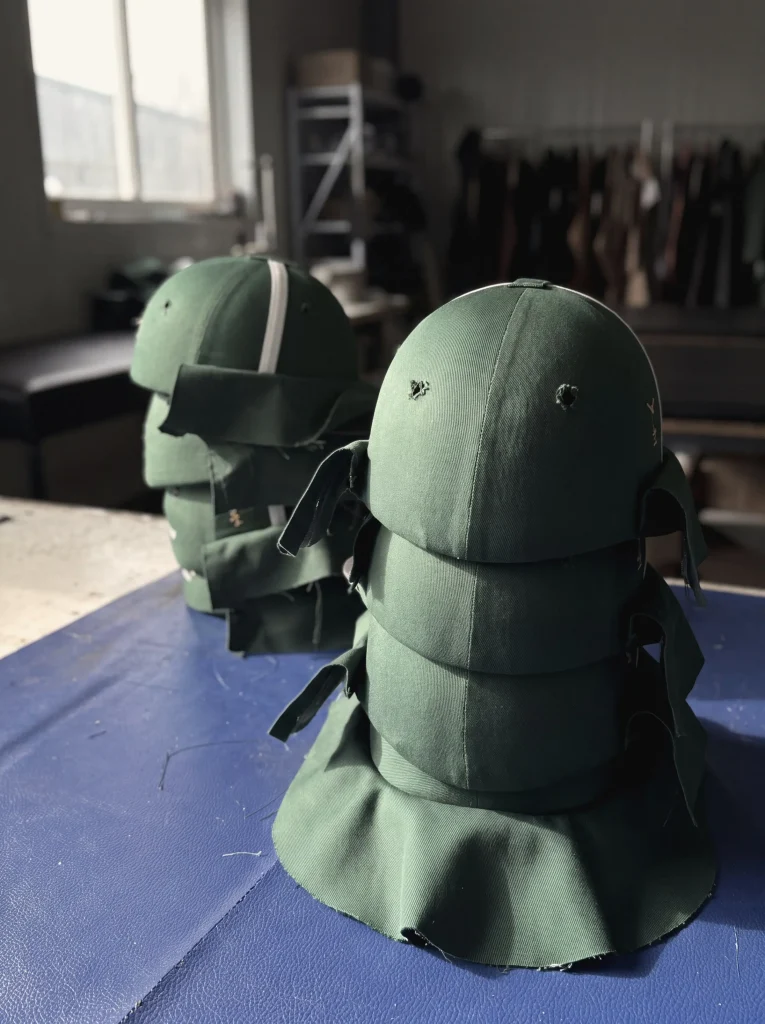 Sewn fabric helmet covers fitted over forming blocks